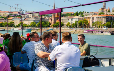 Guests enjoying Budapest Danube River cruise with cityscape views.