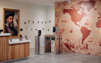 World of Discoveries entrance with explorer portrait and vintage world map.