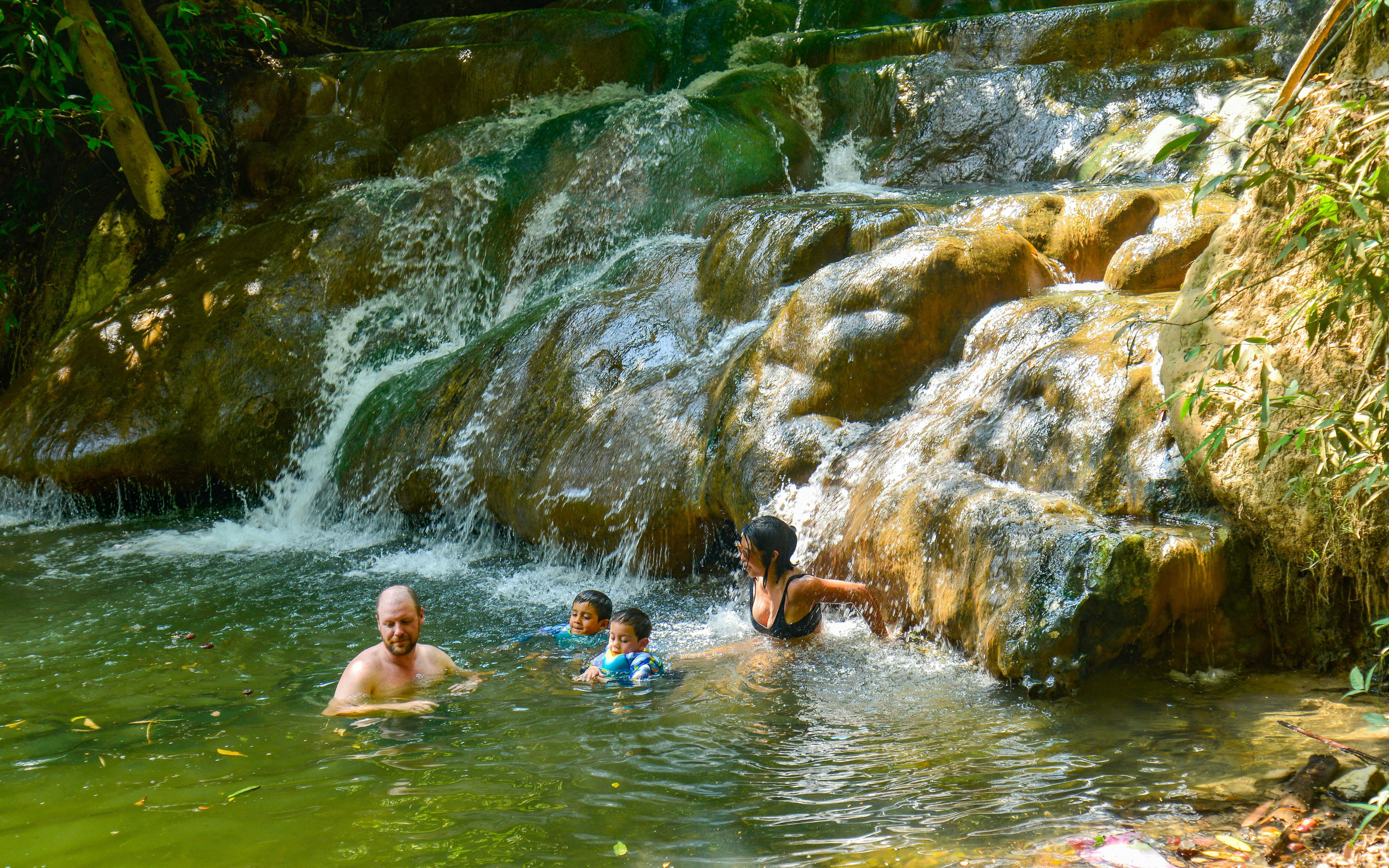 Family enjoying Emerald Pool Hot Springs in Krabi, surrounded by lush greenery.