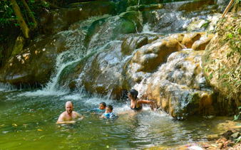 Family enjoying Emerald Pool Hot Springs in Krabi, surrounded by lush greenery.