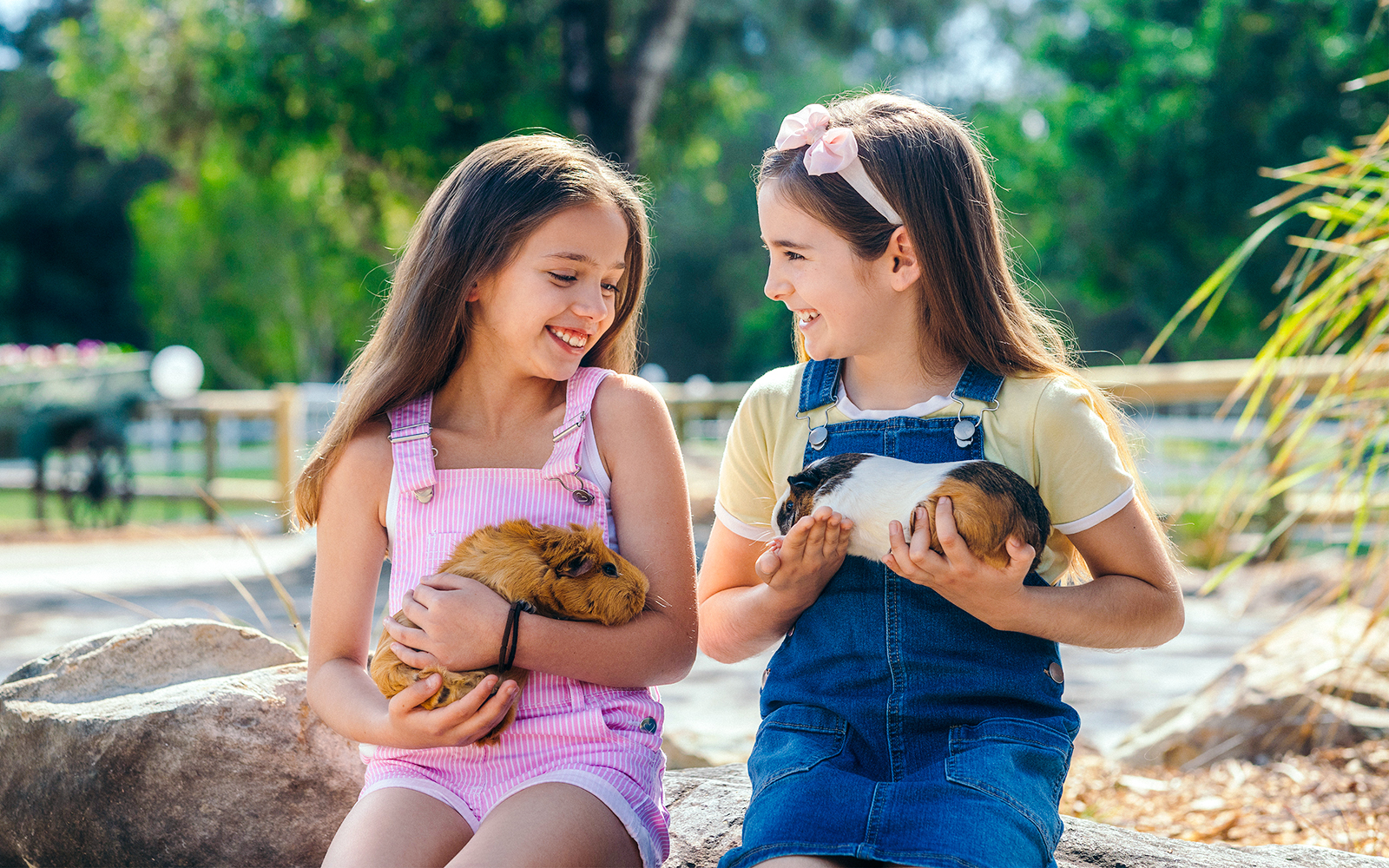 Girls holding guinea pigs at Paradise Country animal nursery, Gold Coast.