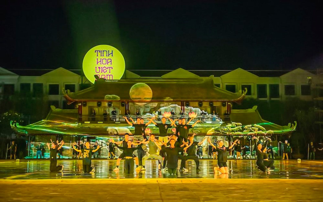 Performers on stage at The Quintessence of Vietnam Show, Hanoi, with traditional backdrop.