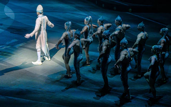 Performer in white leads dancers in La Perle show, Dubai.