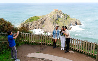Visitors posing at San Juan de Gaztelugatxe, Dragonstone filming location, near San Sebastian.