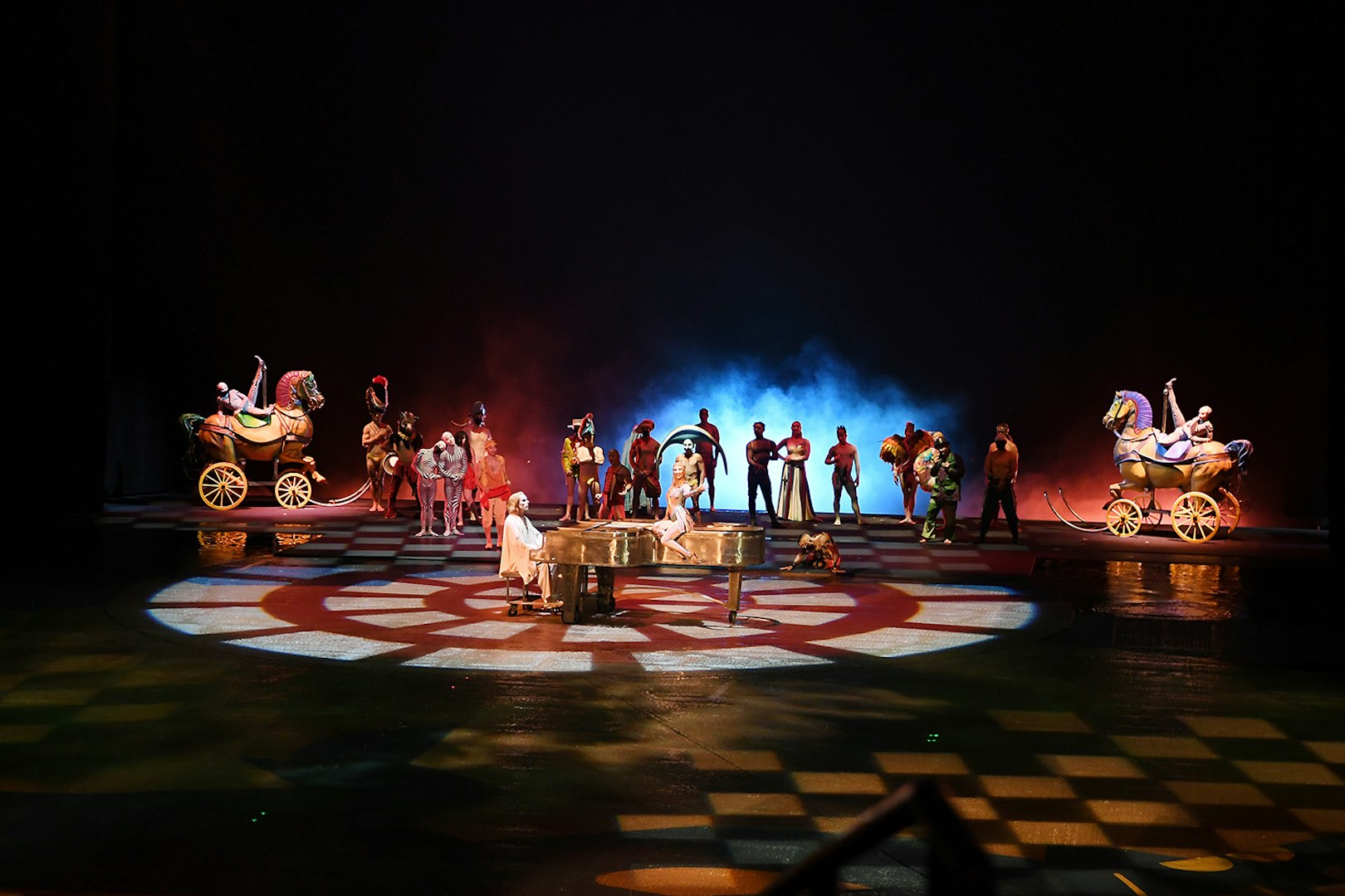 Performers on stage with colorful costumes and props in a theatrical show.