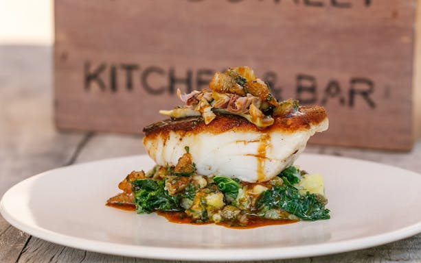 Pan-seared fish with greens at Bread Street Kitchen, Dubai.