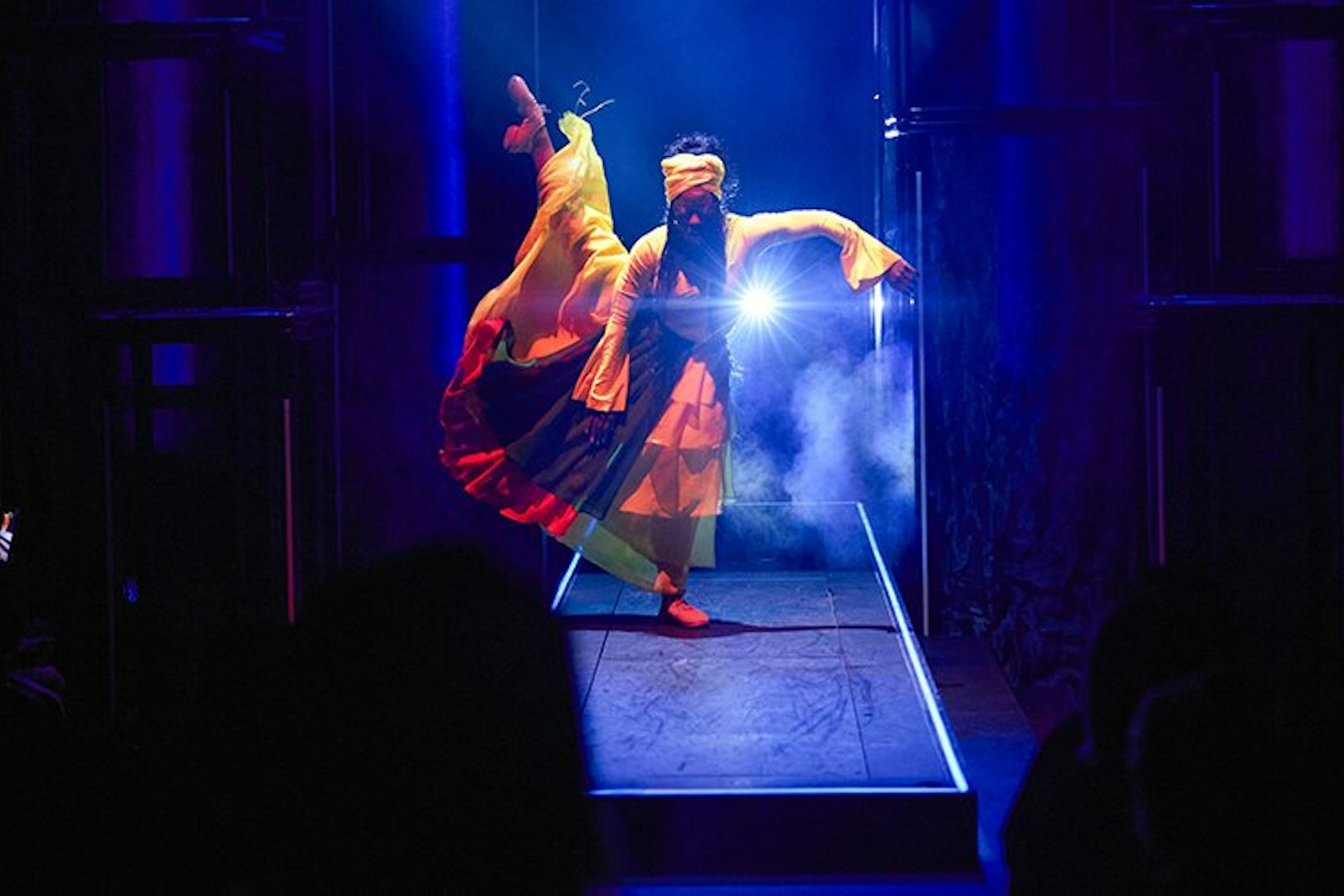 Performer on stage at Bob Marley The Show, Vegas, with vibrant lighting effects.