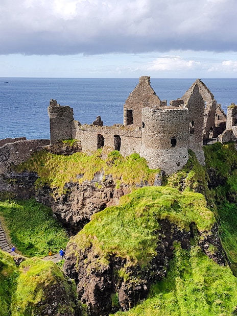 Dunluce Castle ruins on a cliff overlooking the sea in Northern Ireland.