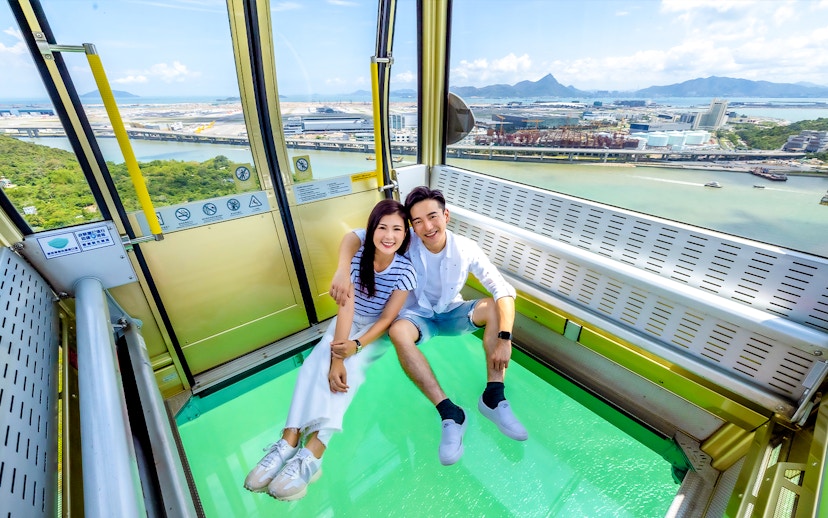 Couple enjoying view from crystal cable car at Ngong Ping 360, Hong Kong.