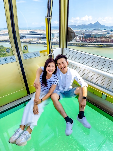 Couple enjoying view from crystal cable car at Ngong Ping 360, Hong Kong.