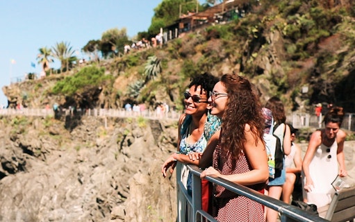 Visitors enjoying the scenic view of Cinque Terre cliffs on a guided tour from Florence.