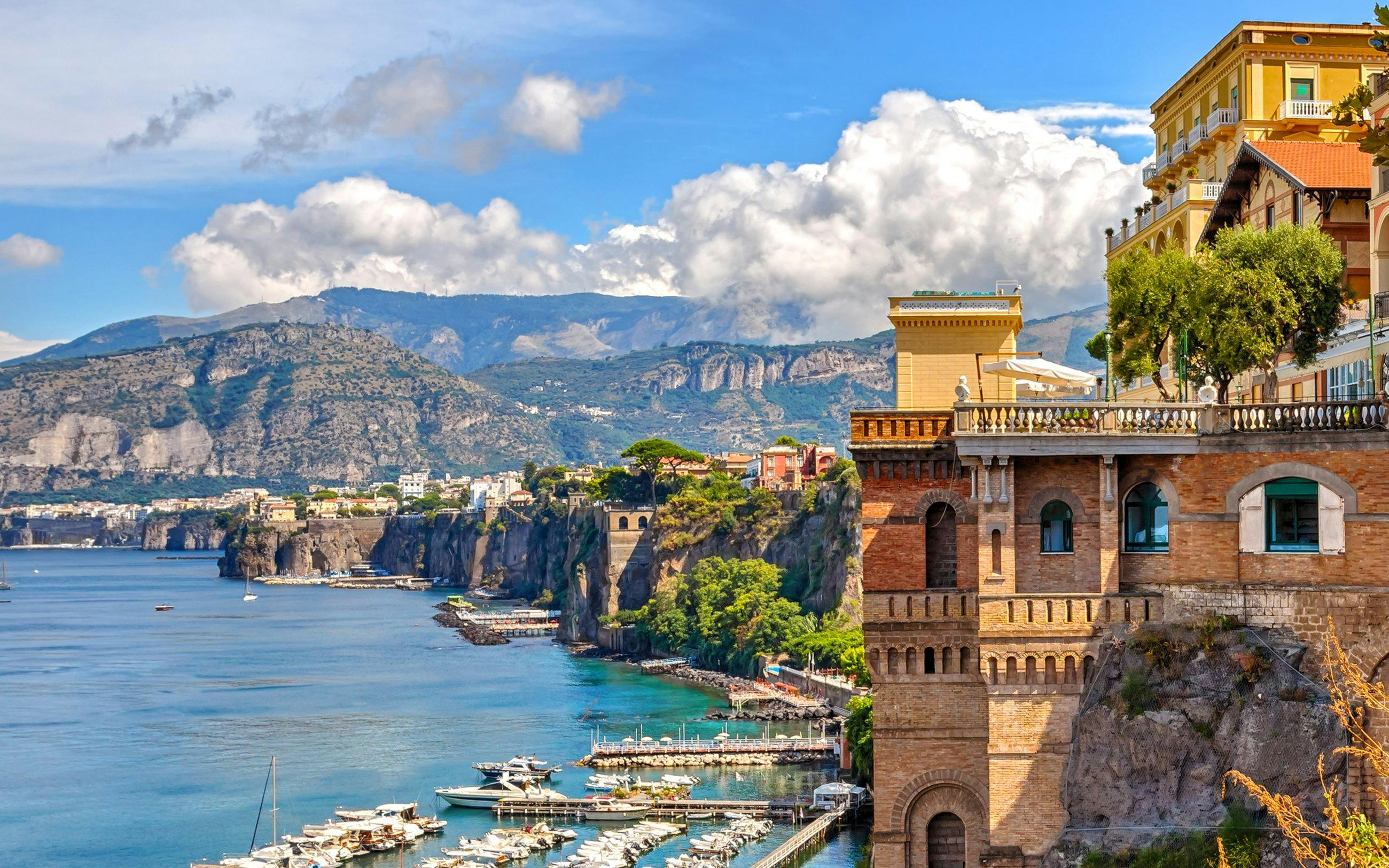 Sorrento coast with cliffs, marina, and historic buildings.
