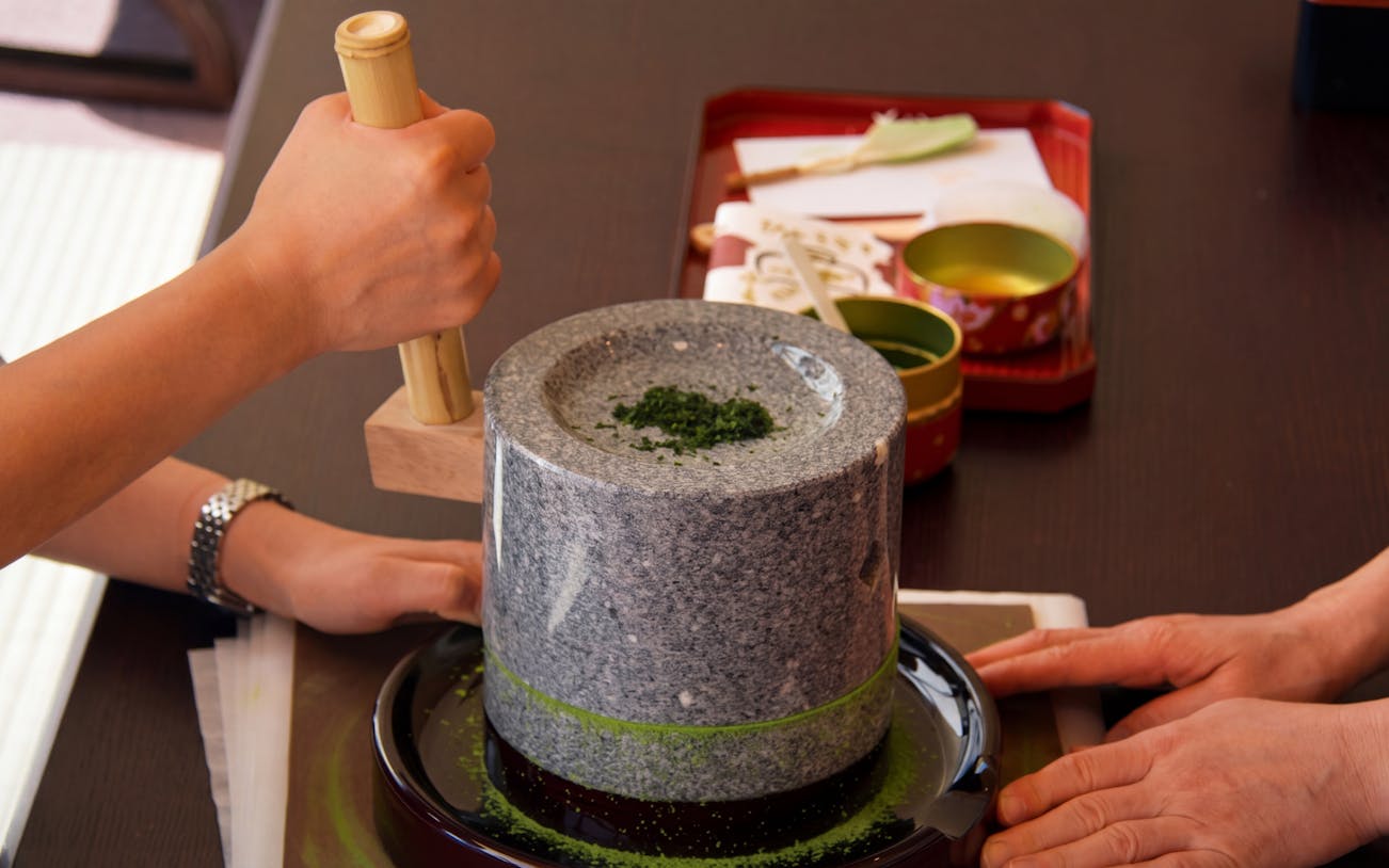Grinding matcha with a stone mill during a Kyoto sweets making class.