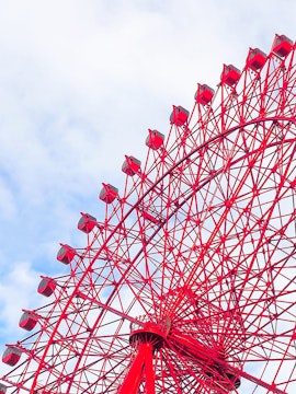 Red HEP Ferris Wheel against a cloudy sky.