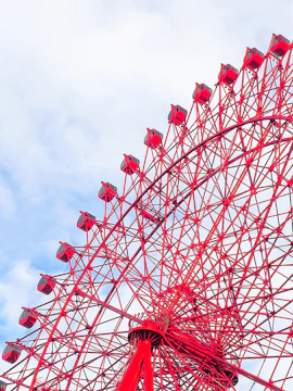 Red HEP Ferris Wheel against a cloudy sky.