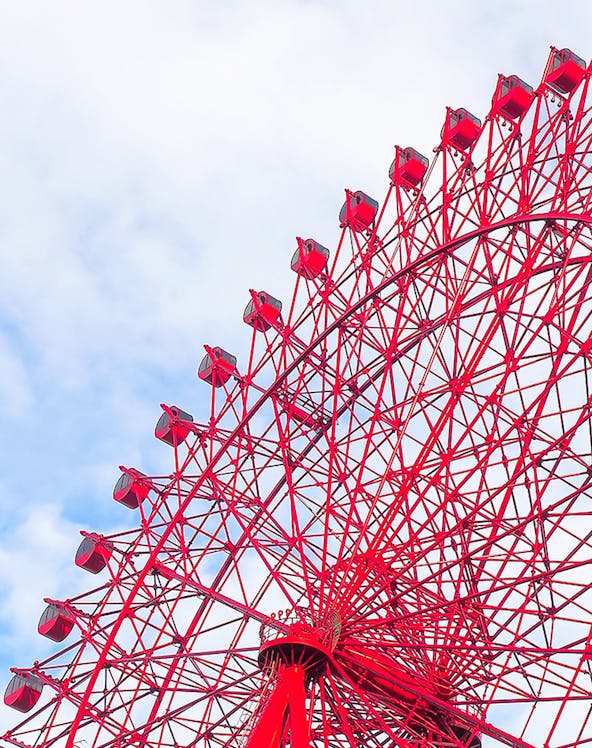 Red HEP Ferris Wheel against a cloudy sky.