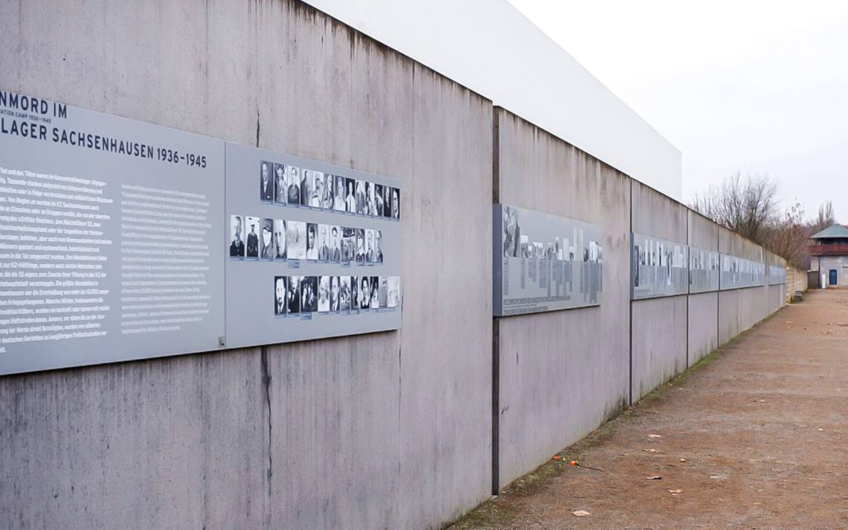 Memorial wall with historical photos and text at Sachsenhausen Concentration Camp.
