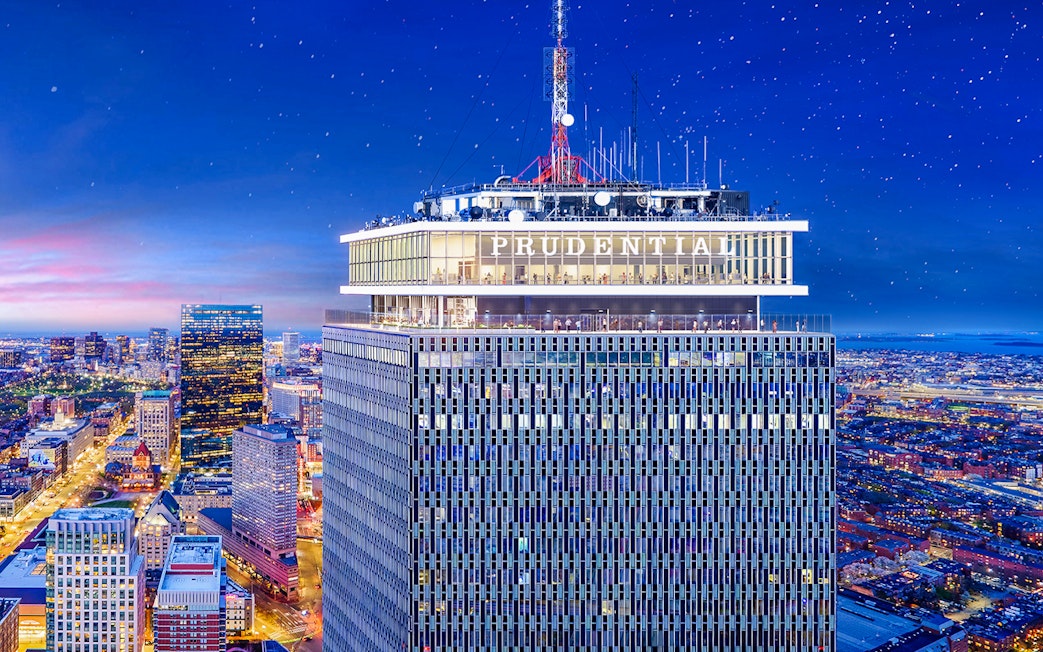 Prudential Tower illuminated at night with cityscape view, Boston.