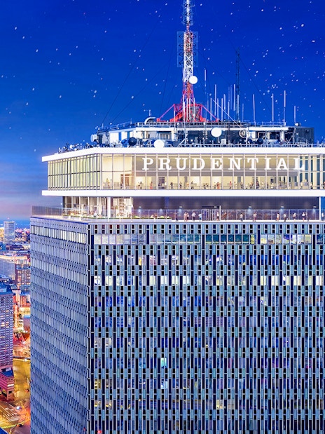 Prudential Tower illuminated at night with cityscape view, Boston.