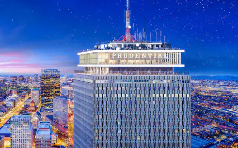 Prudential Tower illuminated at night with cityscape view, Boston.