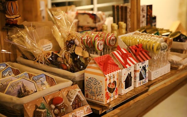 Christmas market stall with festive treats and gift boxes in Budapest.