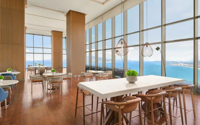 Dining area with ocean view at Hyatt Regency Nha Trang, featuring tables set for Lobster and Seafood BBQ Buffet Dinner.