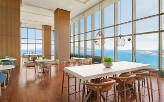 Dining area with ocean view at Hyatt Regency Nha Trang, featuring tables set for Lobster and Seafood BBQ Buffet Dinner.