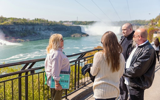 Visitors viewing Niagara Falls from a railing during a half-day tour.