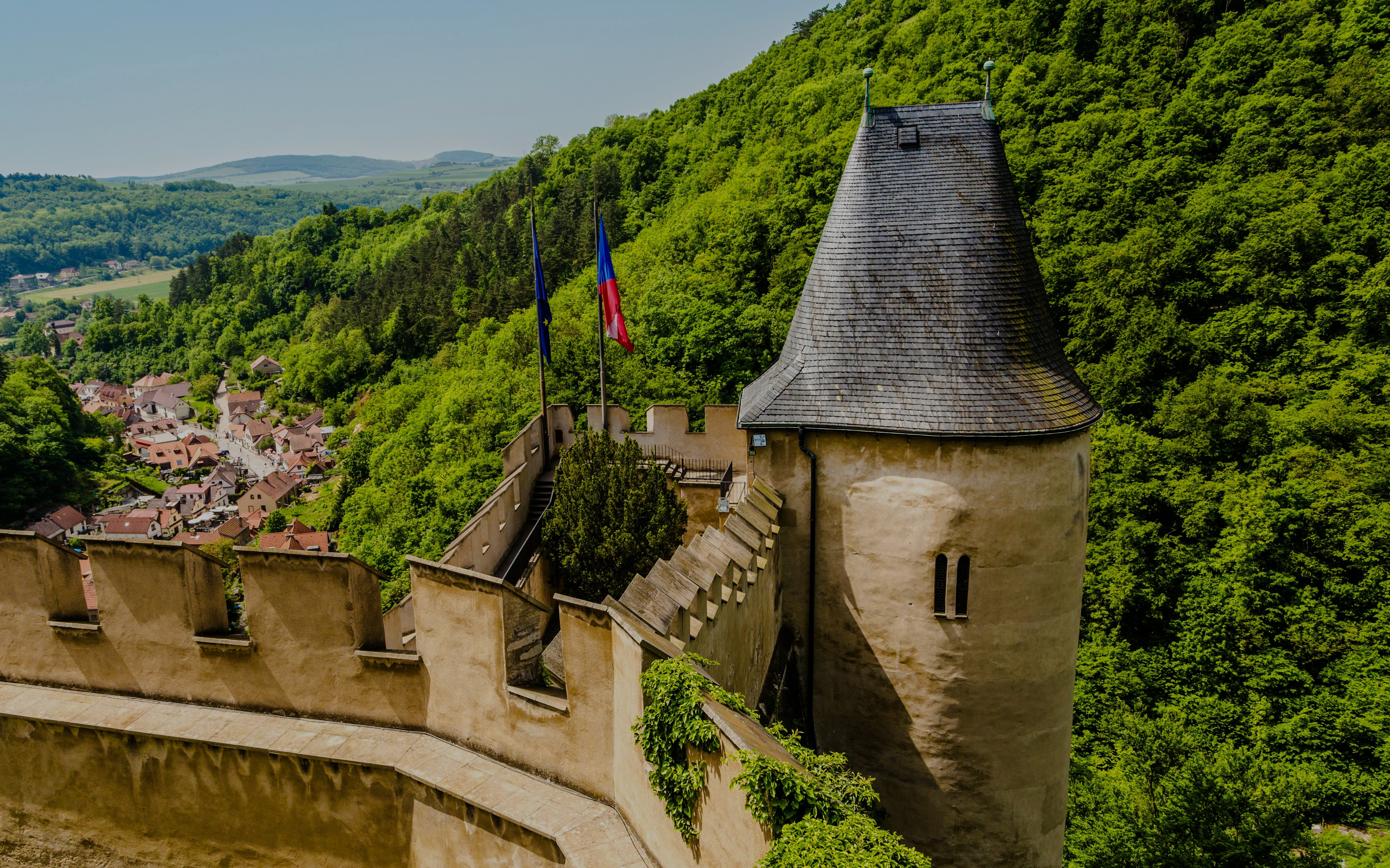 Well tower at Karlstejn Castle surrounded by lush greenery, Czech Republic.
