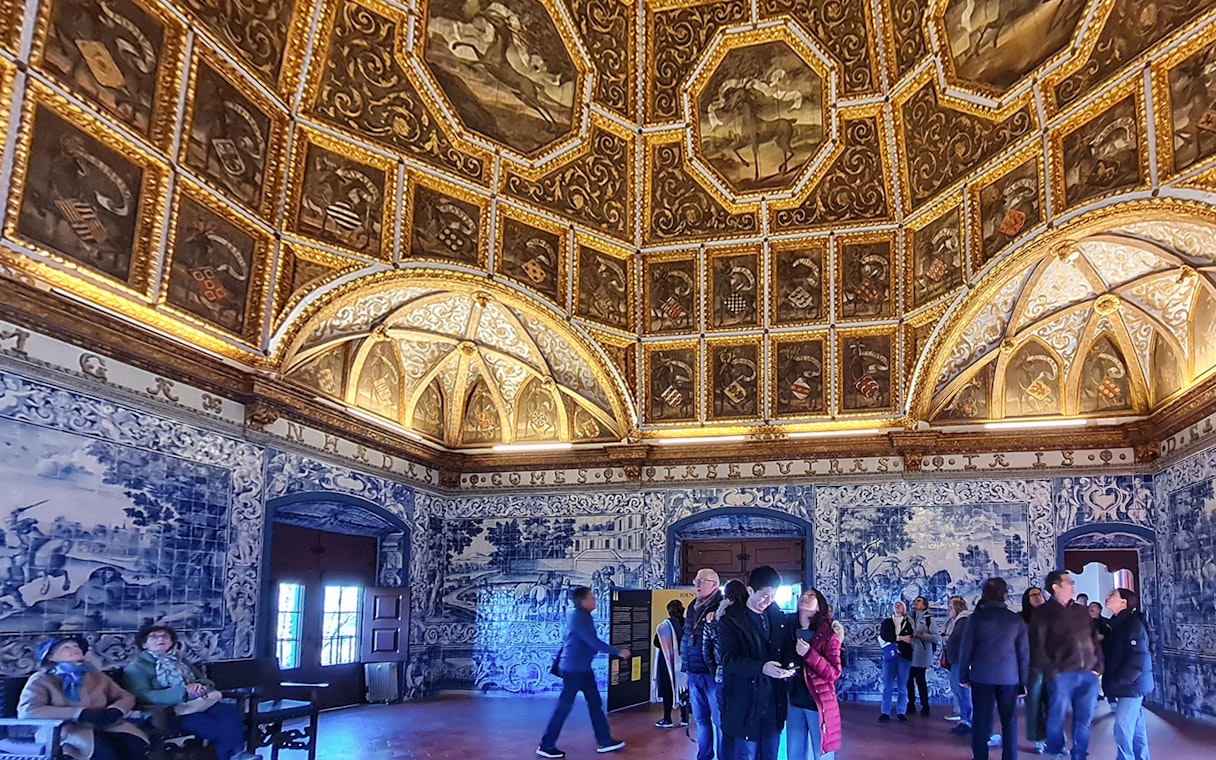 Sintra National Palace interior with ornate ceiling and blue azulejos tiles.