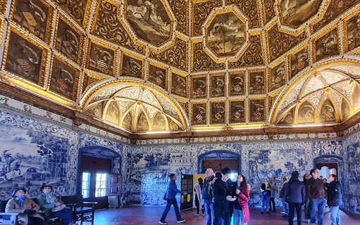 Sintra National Palace interior with ornate ceiling and blue azulejos tiles.