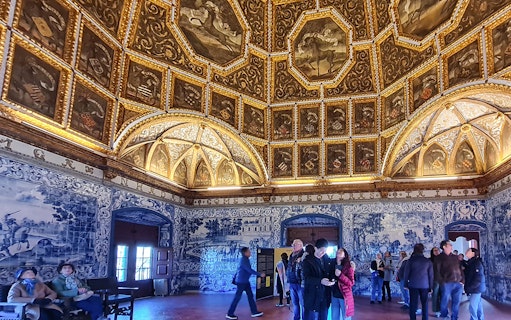 Sintra National Palace interior with ornate ceiling and blue azulejos tiles.