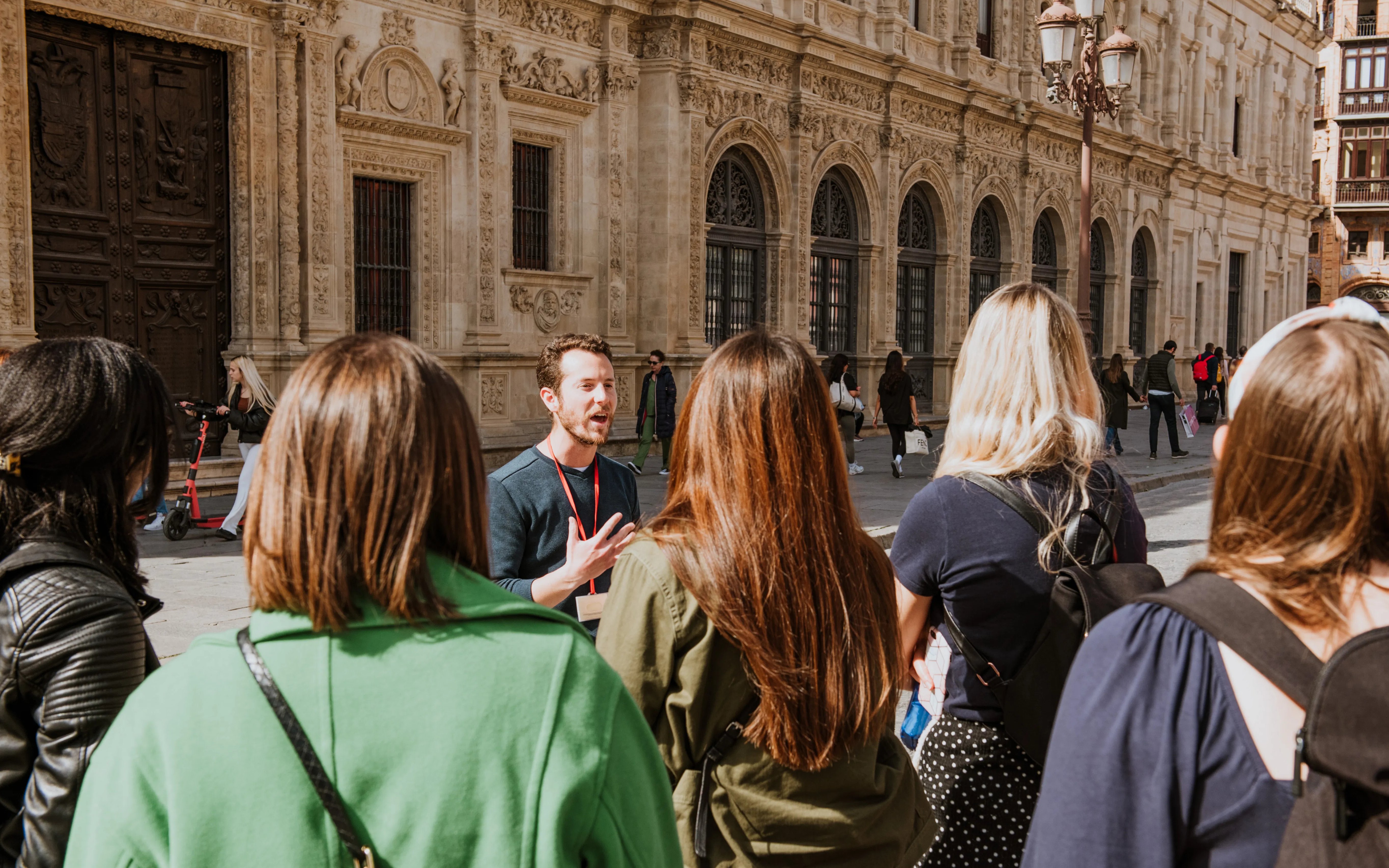 Group on a guided walking tour in front of historic building in Seville, Spain.
