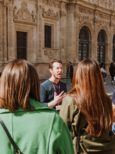 Group on a guided walking tour in front of historic building in Seville, Spain.