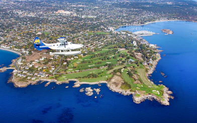 Seaplane flying over Victoria coastline and golf course during scenic tour.