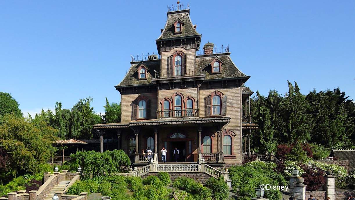 Phantom Manor at Disneyland Paris with eerie Victorian architecture and surrounding gardens.