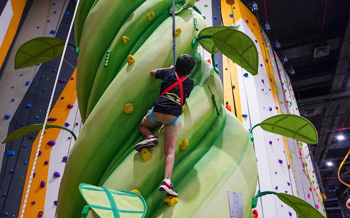 Child climbing indoor wall at Al Qana, Abu Dhabi, part of National Aquarium combo tour.