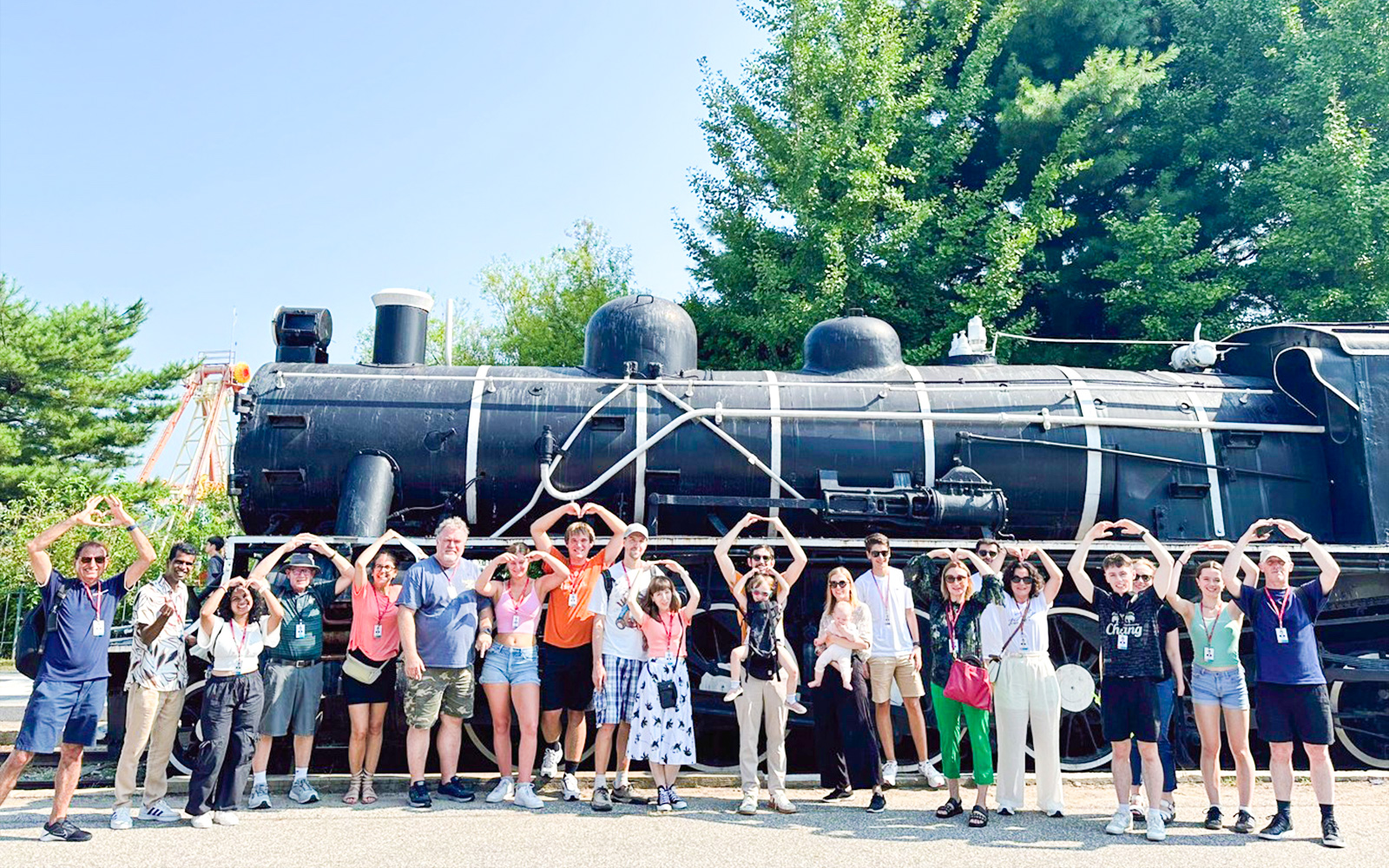 Tourists posing in front of Korean War steam locomotive at Imjingak Park on DMZ tour.