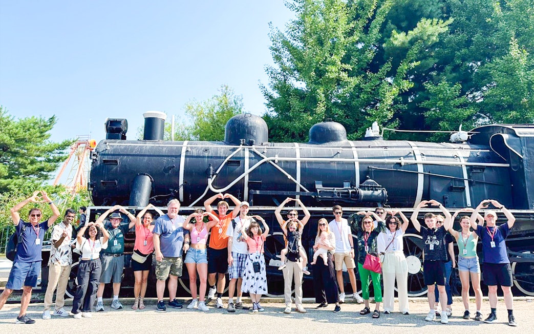 Tourists posing in front of Korean War steam locomotive at Imjingak Park on DMZ tour.