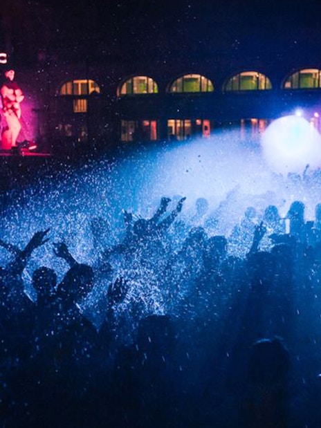 Crowd enjoying a night party with lights and water effects in Budapest.