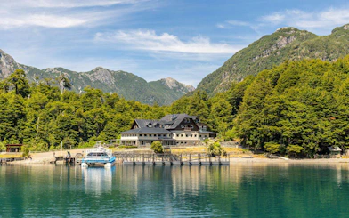 Puerto Blest lodge and dock on Nahuel Huapi Lake, surrounded by dense forest and mountains.