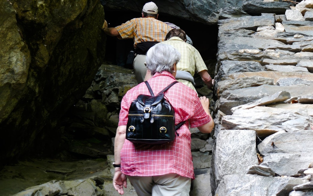 Guests entering St. Ivan Cave through rocky entrance.