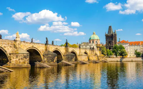Charles Bridge over Vltava River with Prague skyline in the background.