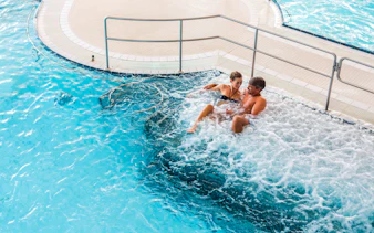 Couple relaxing in a jacuzzi at Chocholow Thermal Baths, Poland.