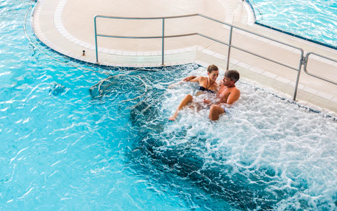Couple relaxing in a jacuzzi at Chocholow Thermal Baths, Poland.