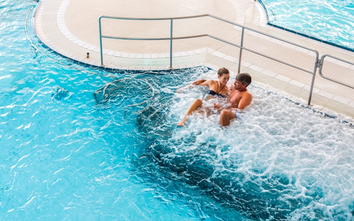 Couple relaxing in a jacuzzi at Chocholow Thermal Baths, Poland.