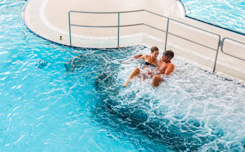 Couple relaxing in a jacuzzi at Chocholow Thermal Baths, Poland.