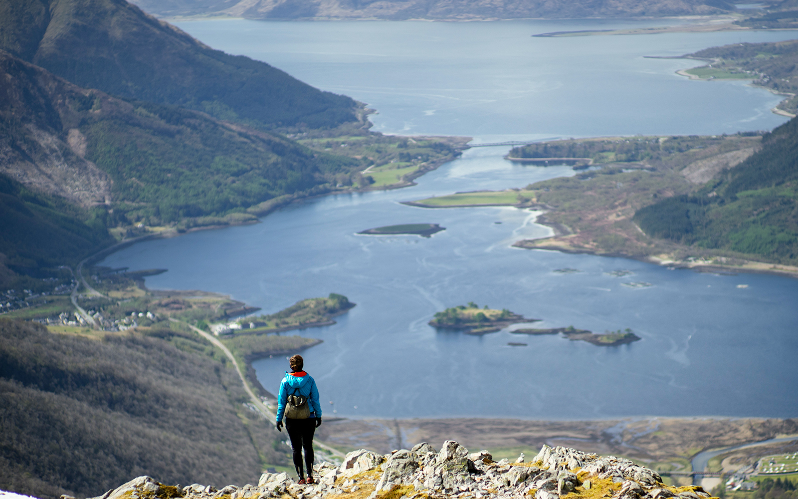 Person overlooking a scenic view of a loch and hills on the St Andrews & Fife tour from Edinburgh.