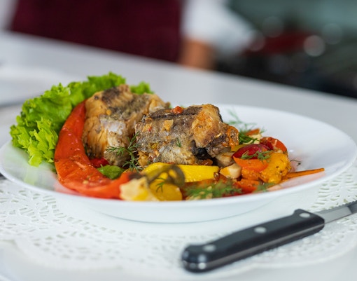 Portuguese river fish dish with vegetables on a white plate.