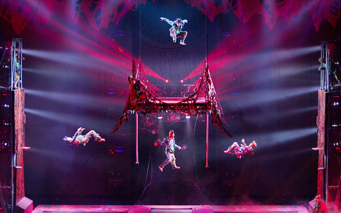 Acrobats performing in Michael Jackson ONE show with vibrant lighting effects.